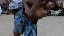 Pegulat bertarung selama turnamen gulat tradisional Sindhi Malakhra di kota pelabuhan Karachi, Pakistan pada Minggu (13/12/2020). Gulat kuno yang dimulai sejak 5.000 tahun lalu ini salah satu olahraga favorit di kalangan pria. (Photo by Asif HASSAN / AFP)