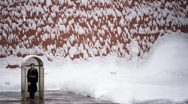 Seorang prajurit berdiri menjaga Makam Prajurit Tak Dikenal setelah hujan salju di Tembok Kremlin, Moskow, Rusia, 7 Februari 2022. (AP Photo/Alexander Zemlianichenko)