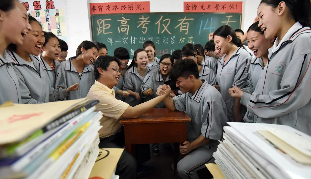 Siswa SMA beradu panco dengan gurunya sebelum ujian masuk perguruan tinggi di sebuah sekolah di Handan, Provinsi Hebei, China utara (24/5). Cara unik ini dilakukan sekolah-sekolah China agar para siswanya lebih rileks menghadapi ujian. (AFP PHOTO/STR)