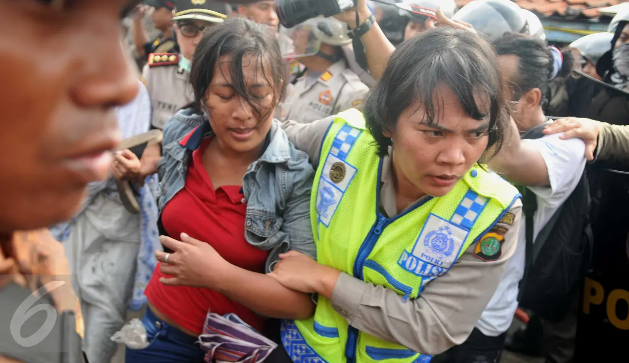 Seorang ibu dibawa oleh petugas polwan saat penggusuran kawasan Pasar Ikan, Penjaringan, Jakarta, Senin (11/4). Para warga yang didominasi perempuan itu ikut menolak penggusuran kawasan tersebut. (Liputan6.com/Gempur M Surya)