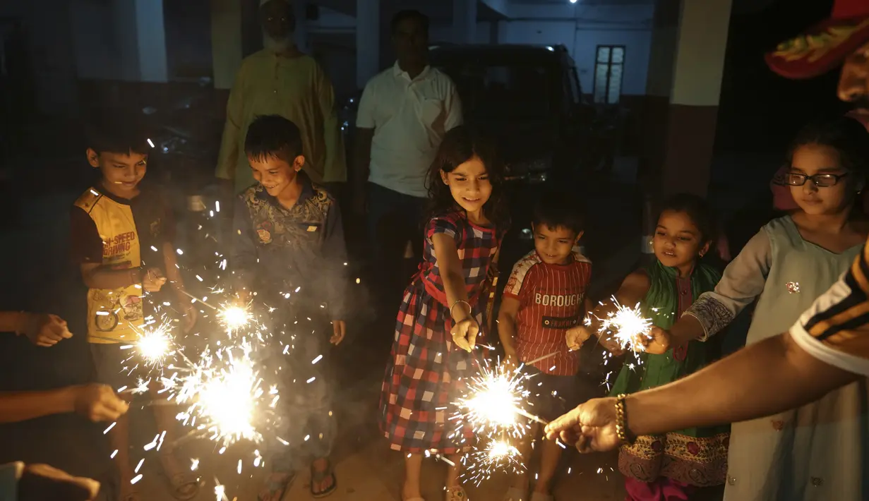 Anak-anak Muslim menyalakan petasan untuk merayakan Diwali, festival lampu, di Hyderabad, India, Senin (24/10/2022). Orang India di seluruh negeri merayakan Diwali, festival Hindu yang melambangkan kemenangan cahaya atas kegelapan. (AP Photo/Mahesh Kumar A.)
