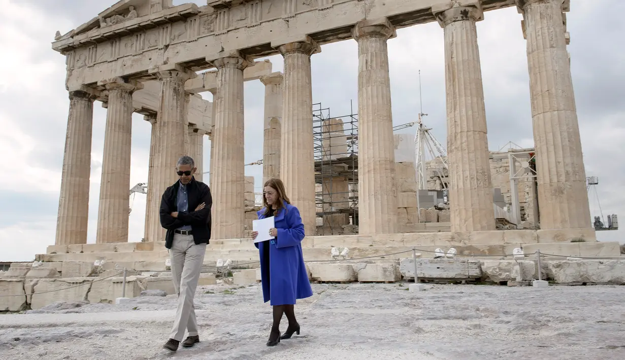 Barack Obama bersama Eleni Banou berjalan mengelilingi situs peninggalan Parthenon saat berkunjung ke Athena, Yunani (16/11). Dalam kunjungan ini Obama meyakinkan negara sekutu Amerika Serikat untuk mempertahankan hubungan baik. (AFP/Brendan Smialowski)