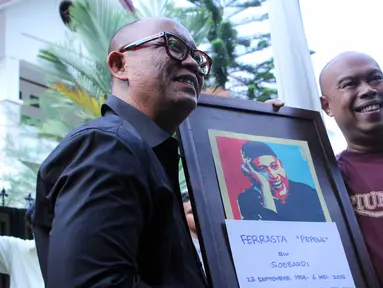 Pembawa acara dan penyanyi, Teuku Edwin dan Jody Sumantri memegang foto almarhum Ferrasta Soebardi alias Pepeng di rumah duka di kawasan Cinere, Depok, Rabu (6/5/2015). Pepeng meninggal dunia di usia 60 tahun. (Liputan6.com/Helmi Afandi)