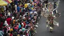 Warga menyaksikan peserta menampilkan kreasi kostum dalam Jember Fashion Carnaval (JFC) di Jember, Provinsi Jawa Timur pada Minggu (4/8/2019). Kegiatan ini mengangkat tema 'tribal grandeur', dengan menghadirkan keagungan 8 suku di dunia. (Photo by JUNI KRISWANTO / AFP)