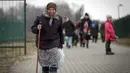 Seorang wanita tua memegang tongkat saat pengungsi, kebanyakan wanita dan anak-anak, tiba di perbatasan di Medyka, Polandia, Sabtu (5/3/2022). Mereka melarikan diri dari invasi Rusia di Ukraina. (AP Photo/Visar Kryeziu)