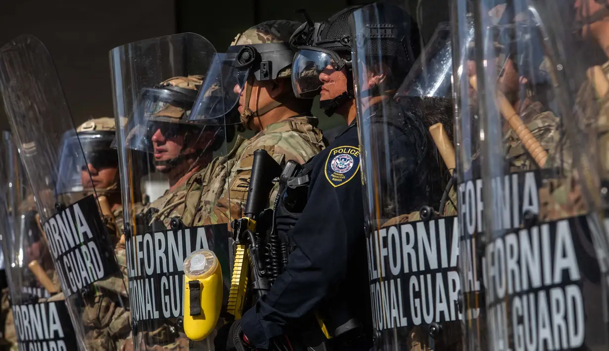 Sebelumnya, kehadiran Garda Nasional terjadi setelah dua hari aksi protes yang dimulai pada Jumat (6/6/2025) di pusat Los Angeles, menyusul penangkapan lebih dari 40 orang oleh otoritas imigrasi federal di berbagai lokasi di kota tersebut. (Apu GOMES/AFP)