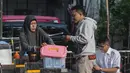 Hal tersebut mengingat sebagian besar pelaku usaha mikro berasal dari kelompok berpenghasilan rendah dan bekerja di sektor informal. Tampak dalam foto, seorang wanita menyajikan sarapan kepada pelanggannya di sebuah warung pinggir jalan, Jakarta, Senin 4 Mei 2026. (BAY ISMOYO/AFP)