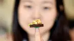Seniman Nguyen Thi Ha An berpose dengan miniatur makanan kreasinya yang bernama "Banh Mi" di studionya, Hanoi, Vietnam, 18 Agustus 2020. Lulusan arsitektur yang kini berusia 28 tahun tersebut mulai membuat miniatur makanan dari tanah liat sejak setahun lalu. (Manan VATSYAYANA/AFP)