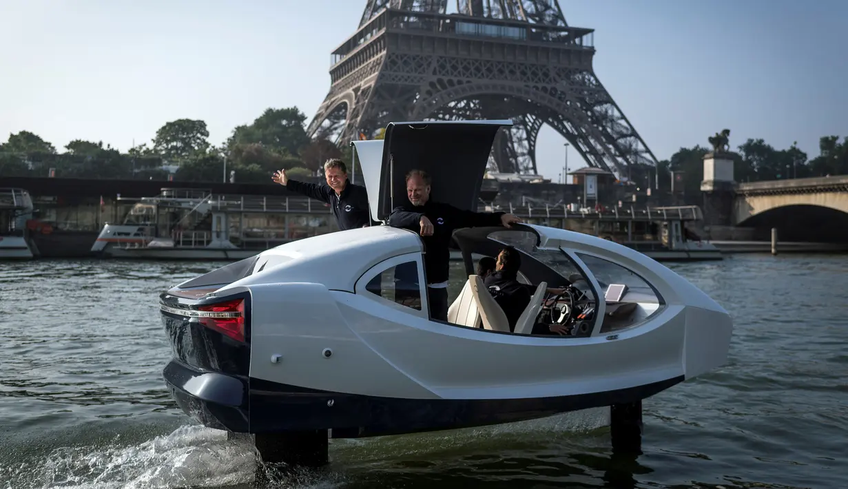 Pendiri Sea Bubbles Alain Thebault (kiri) dan Anders Bringdal (kanan) berdiri di atas kapal "flying taxi" Sea Bubble saat demonstrasi di sungai Seine di Paris, Prancis (20/5). (AFP Photo/Lionel Bonaventure)