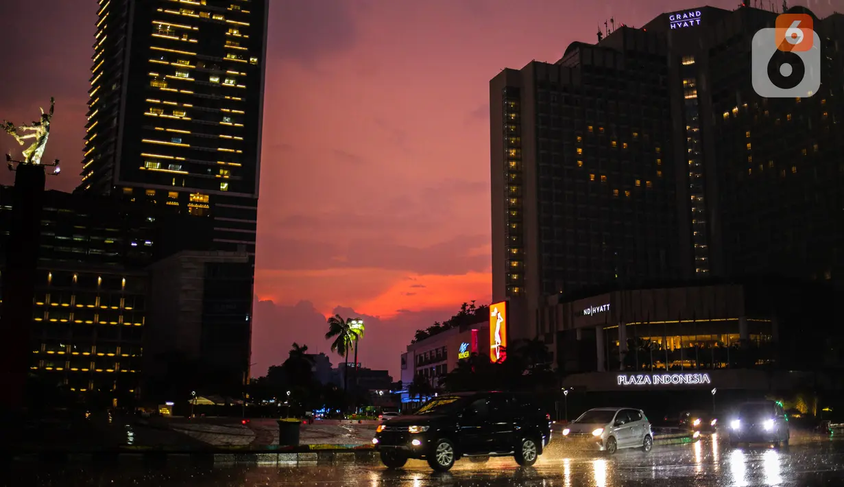 Kendaraan melintas di depan Hotel Grand Hyatt yang menyalakan lampu-lampu kamarnya membentuk lambang hati di kawasan Bundaran HI, Jakarta, Senin (13/4/2020). Aksi itu bentuk ungkapan cinta terhadap para tenaga medis yang berjuang menangani COVID-19 di Indonesia. (Liputan6.com/Faizal Fanani)