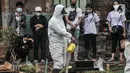 Petugas menyemprotkan disinfektan di area makam pasien Covid-19 di TPU Pondok Kelapa, Jakarta, Selasa (13/7/2021). Tim Koalisi Warga LaporCovid-19 mencatat sebanyak 451 pasien Covid-19 meninggal saat menjalani isolasi mandiri. (merdeka.com/Iqbal S Nugroho)