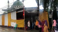 Tamu hajatan berbaris masuk di hajatan nikah di perempatan Buntu, Banyumas. Sementara di dalam tenda, lampu merah menyala(Foto: Liputan6.com/twitter @agungmrheza/Muhamad Ridlo)