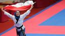 Atlet taekwondo, Defia Rosmaniar, melakukan selebrasi usai berhasil meriah medali emas pertama untuk Indoensia di Asian Games 2018 di JCC, Jakarta, Minggu (19/8/2018). (Bola.com/Peksi Cahyo)