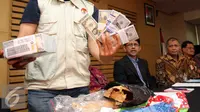 Petugas KPK menunjukan barang bukti uang saat konferensi pers (Liputan6.com/Helmi Afandi)