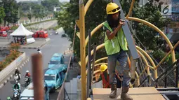 Pekerja menyelesaikan pembangunan Jembatan Penyebaran Orang (JPO) Pasar Minggu di Jakarta Selatan, Kamis (26/9/2019). JPO berdesain artistik senilai Rp 7 miliar tersebut ditargetkan rampung pengerjaannya pada Desember 2019 mendatang. (Liputan6.com/Immanuel Antonius)
