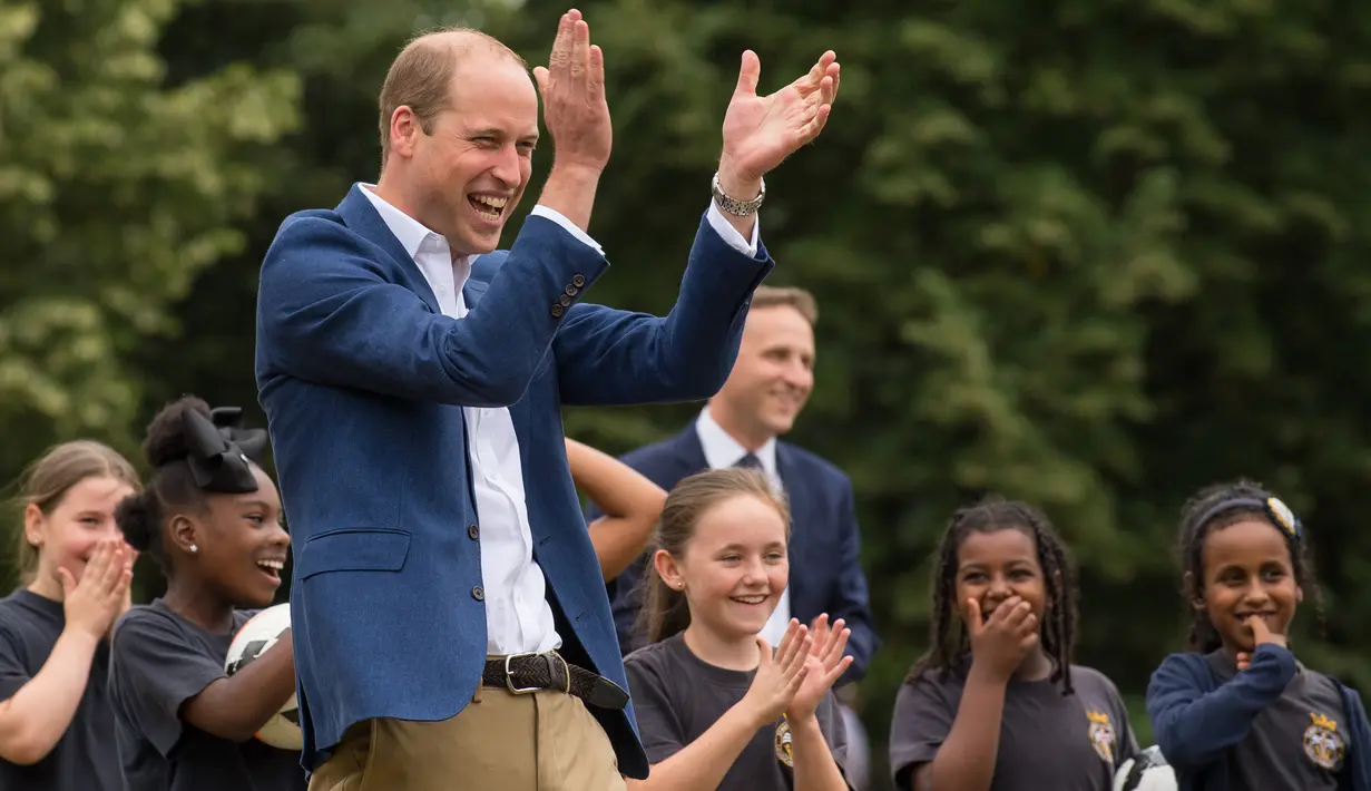 Pangeran William bereaksi sambil mengamati latihan anak-anak program pendidikan sepak bola Wildcats Girls saat mengunjungi tim sepak bola wanita Inggris, di Kensington Palace, London, Kamis (13/7). (Dominic Lipinski / POOL / AFP)