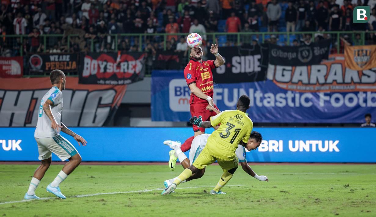 Pemain Persija Jakarta, Marko Simic berusaha mencetak gol ke gawang PSBS Biak, Arjuna Agung dalam laga lanjutan BRI Liga 1 2024/2025 di Stadion Patriot Candrabhaga, Bekasi, Minggu (02/02/2025). (Bola.com/Bagaskara Lazuardi)
