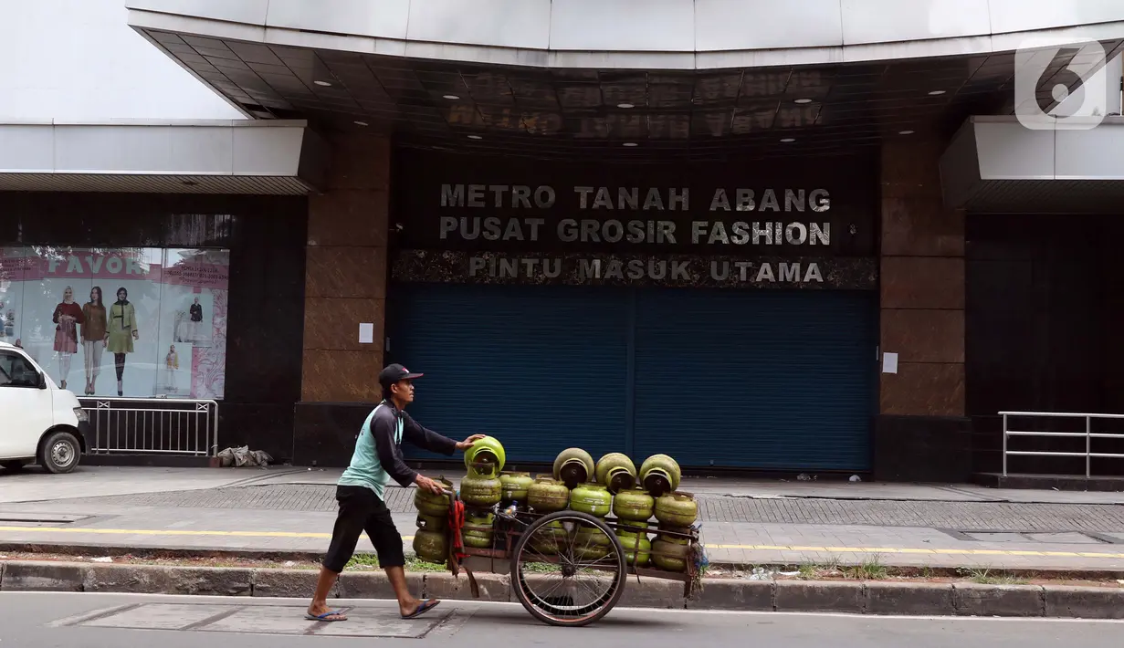 Pedagang gas keliling melintas di depan Metro Tanah Abang yang tutup, Jakarta, Jumat (3/4/2020). Pemerintah menetapkan Pembatasan Sosial Berskala Besar dengan membatasi kegiatan tertentu penduduk di wilayah yang diduga terinfeksi COVID-19. (Liputan6.com/Helmi Fithriansyah)