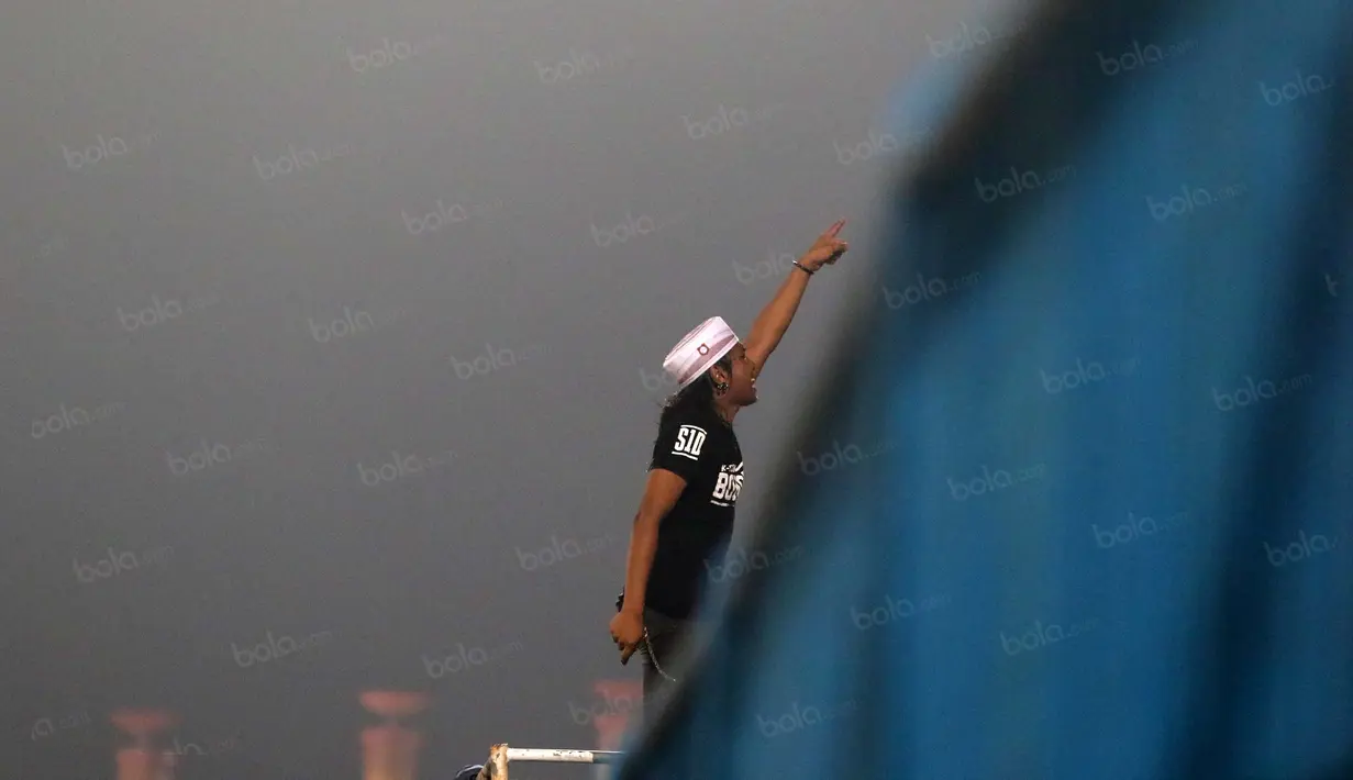 Pemimpin aksi K-Conk Mania memberikan instruksi kepada rekan-rekannya saat mendukung timnya Madura United melawan Persiba Balikpapan pada Torabika SC 2016 di Stadion Gelora Bangkalan, Senin(13/6/2016).  (Bola.com/Nicklas Hanoatubun)