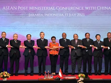 Dari kiri ke kanan, Sekretaris Luar Negeri Filipina Enrique Manalo, Menteri Luar Negeri Singapura Vivian Balakrishnan, Menteri Luar Negeri Thailand Don Pramudwinai, Menteri Luar Negeri Vietnam Bui Thanh Son, Kepala Kebijakan Luar Negeri Partai Komunis China Wang Yi, Menteri Luar Negeri Indonesia Retno Marsudi, Menteri Luar Negeri Malaysia Zambry Abdul Kadir, Menteri Urusan Luar Negeri Kedua Brunei Darussalam Erywan Yusof, Menteri Luar Negeri Kamboja Prak Sokhonn, Menteri Luar Negeri Laos Saleumxay Kommasith, Menteri Luar Negeri Timor Timur Bendito Freitas dan Sekretaris Jenderal ASEAN Kao Kim Moiln bergandengan tangan saat sesi foto pada acara ASEAN Post Ministerial Conference with China di Jakarta, Indonesia, Kamis (13/7/2023). (AP Photo/Tatan Syuflana, Pool)