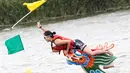 Seorang kapten berhasil meraih bendera usai mencapai garis finish perlombaan tradisional China, Dragon Boat di Taipei, Taiwan, Minggu (28/5). Perlombaan ini untuk mengenang kematian penyair Qu Yuan yang tenggelam pada 278 SM. (AP Photo/Chiang Ying-ying)