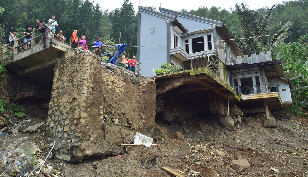 Warga mengamati lokasi bencana longsor di Desa Clapar, Kecamatan Madukara, Banjarnegara, Jawa Tengah, Rabu (30/3). Sebagian warga mengungsi ke tempat aman dan diperkirakan longsoran menutup lahan kebun buah salak seluas 60 hektar. (Foto: Gholib)