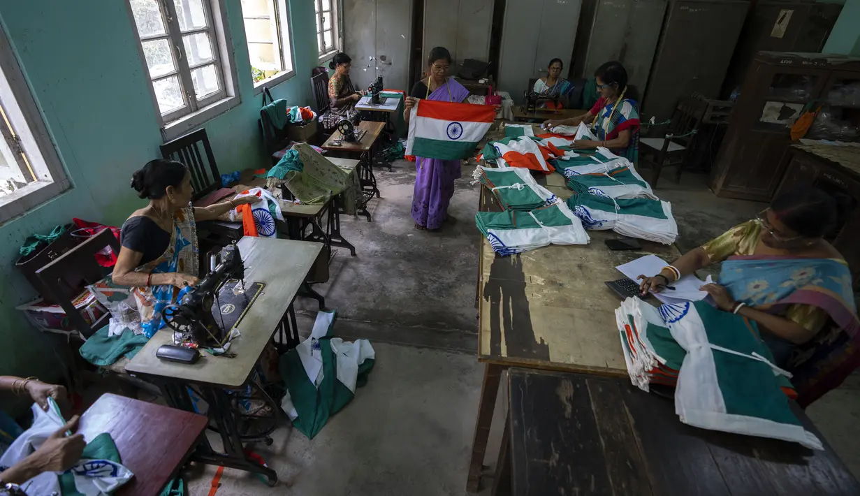 Pegawai pemerintah menjahit bendera tiga warna India di kantor menjelang Hari Kemerdekaan di Gauhati, di negara bagian timur laut Assam, Selasa, 2 Agustus 2022. Perdana Menteri India Narendra Modi telah mengimbau warga untuk mengibarkan atau memajang bendera nasional di Hari Kemerdekaan pada 15 Agustus. (AP Photo/Anupam Nath)