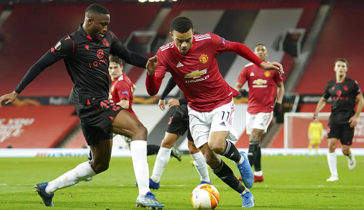 Pemain Manchester United Mason Greenwood (kanan) menggiring bola melewati pemain Real Sociedad Modibo Sagnan pada pertandingan leg kedua babak 32 besar Liga Europa di Old Trafford, Manchester, Inggris, Kamis (25/2/2021). Laga berakhir 0-0 dan MU lolos ke babak 16 besar. (AP Photo/Dave Thompson)