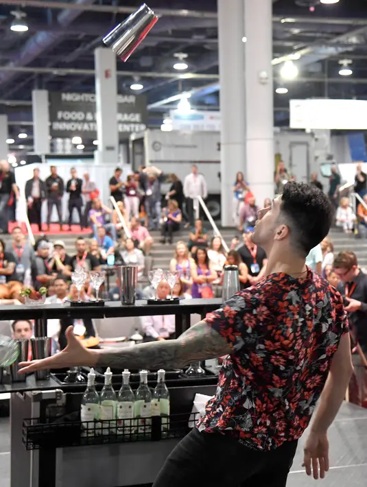 Bartender Cruz Guitierrez saat berkompetisi dalam Shake It Up Flair Competition pada hari kedua dari Nightclub & Bar Convention and Trade Show tahunan ke-34 di Las Vegas, Nevada (26/3). (AFP Photo/Ethan Miller)