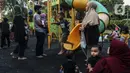 Anak-anak didampingi orangtua bermain di RPTRA Bhineka Jakarta Selatan, Sabtu (30/7/2022). Selain menjadi alternatif mengisi libur bersama keluraga, taman juga menjadi ruang bagi warga untuk berinteraksi sosial sekaligus mengeduksi anak untuk bermain bersama teman-teman dengan wahana yang tersedia. (Liputan6.com/Johan Tallo)