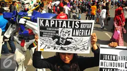 Seorang wanita menunjukan poster saat melakukan aksi terkait kebijakan Presiden Amerika Serikat Donald Trump di Jakarta, Minggu (5/2). (Liputan6.com/Angga Yuniar)