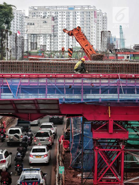 Kendaraan melintas di bawah pembangunan proyek Light Rail Transit (LRT) Jabodebek fase I di kawasan Cawang, Jakarta, Senin (14/1). Progres konstruksi stasiun LRT Cawang, Jakarta Timur sudah mencapai 62,2 persen. (Liputan6.com/Faizal Fanani)