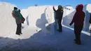 Orang-orang bermain di labirin salju yang dibuat oleh pasangan suami istri, Clint dan Angie Masse di St. Adolphe, Kanada, 3 Maret 2019. Labirin seluas 2.789 meter per segi ini telah memecahkan rekor sebagai yang terbesar di dunia. (Thibault JOURDAN/AFP)