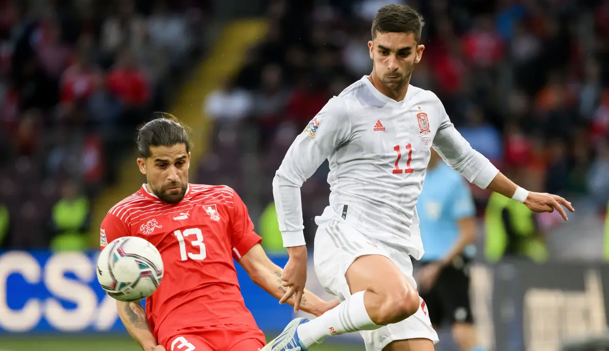 Pemain Swiss Ricardo Rodriguez (kiri) berebut bola dengan pemain Spanyol Ferran Torres pada pertandingan sepak bola UEFA Nations League di Stadion Stade de Geneve, Jenewa, Swiss, 9 Juni 2022. Spanyol menang 1-0. (Laurent Gillieron/Keystone via AP)