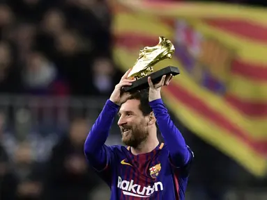 Bintang Barcelona, Lionel Messi mengangkat sepatu emas yang diterima setelah berhasil menjadi pencetak gol terbanyak Eropa pada 2017 di Camp Nou stadium, Barcelona, (17/12/2017). (AFP/Javier Soriano)