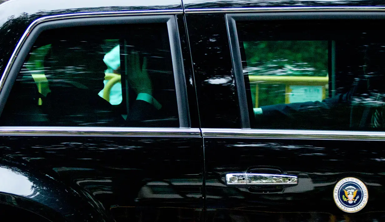 Presiden AS Donald Trump melambaikan tangan ketika mobilnya meninggalkan hotel Shangri-La, Singapura, Selasa (12/6). Trump dan pemimpin Korea Utara, Kim Jong-un akan bertemu dalam KTT Korea Utara-AS di Hotel Capella, Pulau Sentosa. (AP/Gemunu Amarasinghe)