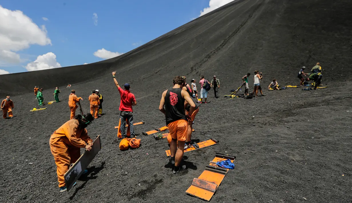 Antusias sejumlah wisatawan saat bersiap bermain sandboarding atau berseluncur pasir menuruni gunung berapi Cerro Negro di Leon, Nikaragua, 24 September 2016. Gunung Cerro Negro salah satu gunung api yang masih aktif di Nikaragua. (INTI Ocon/AFP)