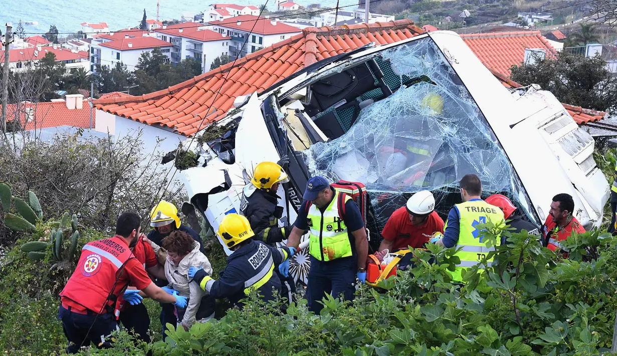 Petugas penyelamat mengevakuasi korban kecelakaan sebuah bus pariwisata di Kota Canico, Pulau Madeira, Portugal, Rabu (17/4). Sebanyak 28 orang yang sebagian besar turis dari Jerman, meninggal dunia, sementara 22 lainnya terluka dalam insiden tersebut. (Rui Silva/Aspress/Global Imagens via AP)