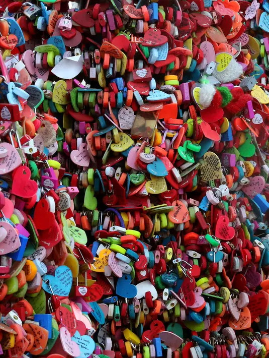 Ribuan gembok cinta penuh warna menutupi pagar di Namsan Seoul Tower, Korea Selatan, Selasa (29/1). Setiap gembok cinta biasanya ditulisi dengan nama pasangan, pesan dan tanggal pemasangan gembok. (AP/Ahn Young-joon)
