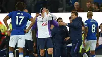 Penyerang Tottenham Hotspur, Son Heung-min, tampak menyesal usai melakukan pelanggaran terhadap gelandang Everton, Andre Gomes, pada laga Premier League di Goodison Park, Minggu (3/11). Tekel tersebut menyebabkan Gomes mengalami patah kaki. (AFP/Oli Scarff)