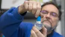 Pemilik perusahaan Original Vienna Snow Globes, Erwin Perzy III merakit bola salju yang berisi gulungan kertas toilet di Wina, Austria, pada 17 April 2020. Bola salju yang memiliki desain istimewa ini terinspirasi dari panic buying pada awal virus corona Covid-19. (ALEX HALADA/AFP)