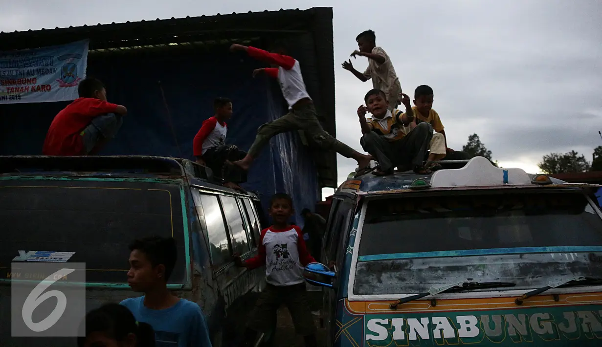 Sejumlah anak terlihat bermain di atas mobil di pengungsian Sinabung, Desa Batu Karang, Medan, Sabtu (4/7/2015). Sebanyak 1254 jiwa dari desa Gursinayan sudah mengungsi selama 1 bulan. (Liputan6.com/JohanTallo)