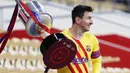 Striker Barcelona, Lionel Messi, mengangkat trofi usai menjuarai Copa del Rey di Stadion Olimpico de Sevilla, Minggu (18/4/2021). Barcelona menang 4-0 atas Athletic Bilbao. (AP/Angel Fernandez)
