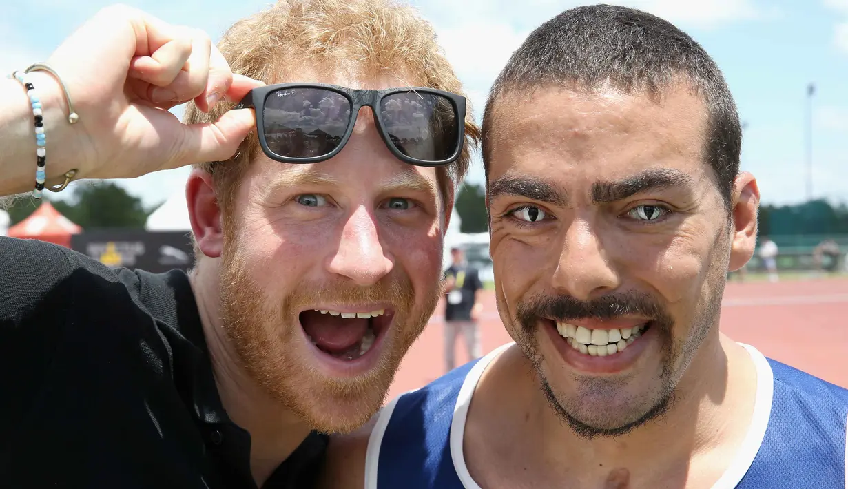 Pangeran Harry berfoto dengan atlet AS, Michael Kacer sebelum bertanding pada ajang ajang Invictus Games Orlando 2016 di ESPN Wide World of Sports complex, (10/5/2016), Lake Buena Vista, Florida.   (Chris Jackson/Getty Images for Invictus/AFP)