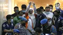 M Rizieq Shihab (tengah) digiring petugas saat meninggalkan gedung Ditreskrimum Polda Metro Jaya, Jakarta, Minggu dini hari (13/12/2020). Rizieq Shihab ditahan setelah menjalani pemeriksaan sebagai tersangka penghasutan dan kerumunan di tengah pandemi COVID-19. (Liputan6.com/Helmi Fithriansyah)