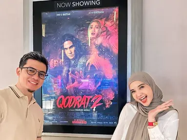 Zaskia Sungkar dan Irwansyah tampil ceria dan antusias saat berpose di depan poster film 'Qodrat 2'. Keduanya sangat mendukung film terbaru Acha Septriasa. Meski Acha tak tampak di sana, ia mengucapkan terima kasih atas support yang diberikan. (Liputan6.com/IG/@zaskiasungkar15)
