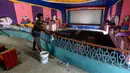 Pekerja membersihkan ruang bioskop sebagai persiapan kemungkinan pembukaan kembali setelah pemerintah melonggarkan pembatasan Covid-19, di Chennai, Sabtu (3/10/2020). Jumlah kematian di India akibat virus corona meningkat melewati 100.000 pada Sabtu, 3 Oktober 2020. (Arun SANKAR/AFP)