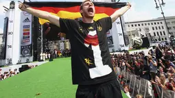 Pemain belakang Timnas Jerman, Per Mertesacker, berdiri dan berteriak saat perayaan kemenangan Der Panzer di Berlin, (15/7/2014). (REUTERS/Alex Grimm/Pool)