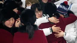 Pemain tim hoki wanita Korea Utara memeluk rekannya asal Korea Selatan saat akan kembali ke negaranya usai mengikuti Olimpiade Pyeongchang di Olympic Village, Gangneung, Korea Selatan, Senin (26/2). (Yun Dong-jin/Yonhap via AP)
