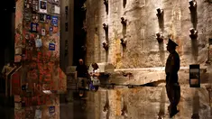 Pengunjung melihat "The Last Column" di depan dinding asli World Trade Center di National September 11 Memorial and Museum, Manhattan, AS (1/9). Pameran ini  diberi nama 'Rendering the Unthinkable: Artists Respond to 9/11'. (REUTERS/Andrew Kelly)